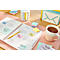 Un agenda avec des post-it, un stylo et une tasse de thé sur un bureau rose.