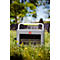 Eine graue Pramac Powerstation steht in einer Frühlingswiese mit gelben Blumen unter freiem Himmel.