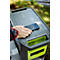Eine Hand legt ein Smartphone zum kabellosen Laden auf eine graue Powerstation mit neongrünen Akzenten.
