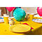 Ein festlich gedeckter Tisch mit gelber Tischdecke, gelben Papptellern und Bechern. Dazu Ballons, Dekorationen und Süssigkeiten.
