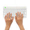 Hände tippen auf einer weißen Tastatur mit Aufdrucken. Oben links Logo von T-go. Schwarze Schriftzeichen.