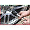 Hand mit Werkzeug an einem Alufelgen-Rad. Im Hintergrund ist ein Audi-Logo zu sehen.