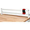 Wit geleidesysteem op een houten plank. De rode knop is een centraal element.