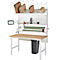 Werkstation met tafel, planken en verpakkingsmaterialen.