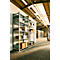 Une étagère en métal remplie de cartons dans un entrepôt lumineux au sol pavé.