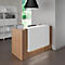 Reception desk with white front and wood paneling. A black lamp hangs above.