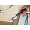 A hand holds a black tool to cut open a cardboard box. The tool is engraved with "regur.com".