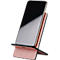 Smartphone in a pink and black stand. The screen is black and reflecting. The stand has a curved shape.