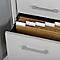 Open drawer of a white filing cabinet filled with brown documents and white tabs.