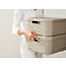 Person holding two beige storage boxes. The boxes are stacked on top of each other and have recessed handles.