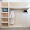 Ein weisser Einbauschrank mit Bademänteln, Kleiderbügeln, Hausschuhen und einem Safe.