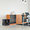 Black safe with digital lock in front of wooden cabinet in modern office. Above, pendant lamps.