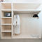 Beige inbouwkast met badjassen, hangers, kluis en slippers.