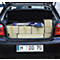 Open trunk of a black car, packed with boxes and an item.