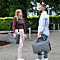 Deux personnes avec des sacs d'ordinateur portables gris discutent. Une femme porte un sac sur son épaule, l'homme dans sa main.
