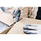 Close-up: Person opening box with utility knife, gray gloves. Other boxes in the background.