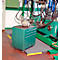 Green toolbox with wheels and mounted machine. In the background another machine and pipes.