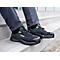 Black Uvex safety shoes on feet, sitting on a staircase.