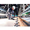 A man in work clothes kneels at a rail, holding a tool and screwing. He is wearing a helmet, gloves.