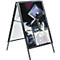 Black A-shaped advertising sign, showing a film or movie theme.