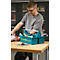 Un homme avec des lunettes travaille sur une table. Devant lui, une boîte à outils bleue avec des outils, imprimé : Schäfershop.