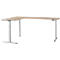 An L-shaped desk, light brown tabletop on a silver, height-adjustable frame.
