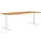 Bureau ergonomique brun clair avec pieds blancs réglables en hauteur. Le plateau de la table a une forme incurvée.