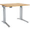 Height-adjustable desk with a light brown tabletop and silver legs. Control panel under the table.