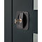 Close-up of a black door handle with a key inserted. The handle is rectangular with rounded corners.