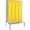 A locker with four yellow doors and a bench in front.