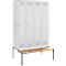 White locker with four doors, with a bench in front.