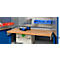 Workbench with tools and work materials. Drill, screws, etc. are on the wooden top. Background: perforated wall.