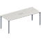 White, rectangular conference table with gray legs and an integrated power outlet.