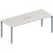 Rectangular, light-colored conference table with four gray legs and a recessed area for cables.