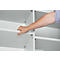 Hand inserting shelf. White shelves in a light-colored cabinet, detail shot.