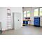 Taller con banco de trabajo, armario, escalera y estanterías con contenedores azules. Ambiente luminoso con ventanas.