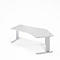 Un bureau d'angle blanc réglable en hauteur avec un bord incurvé sur fond blanc.