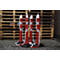 Four red and white bollards with chains in front of wooden pallets.