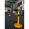 Yellow bollards with black bands, connected by chains, stand in a warehouse.