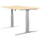A height-adjustable desk with a light brown tabletop and silver legs.
