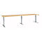 A long, height-adjustable desk with a light wood top and silver legs.