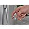 A hand holding a key in front of a door. The key is in a transparent case.