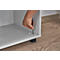 Hand with Allen key inserts screw into furniture. Furniture stands on black leg. Wooden floor.