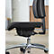 Close-up of a black office chair. Padded seat, chrome frame, casters, ergonomic backrest.