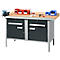 Werkbank met metalen frame en houten blad, laden, gereedschap, een bankschroef en opbergdozen.