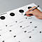 Person schreibt mit Stift in einen grossen, weissen Kalender. Der Kalender ist mit Wochentagen beschriftet und trägt handschriftliche Notizen.