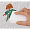 Een hand veegt een kindertekening van een muur met een witte spons. De tekening toont een oranje en groene figuur.