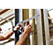 Une personne serre un composant sur un pilier à l'aide d'une pince.