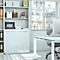 Un bureau avec un bureau blanc, une chaise, une fenêtre et une étagère. Sur l'étagère se trouve un coffre-fort.