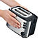 Ein Mann hält einen silbernen Toaster mit schwarzem Rahmen und Knöpfen.
